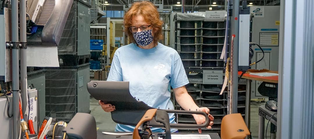 Foto von Andrea Letzybyl bei der Arbeit. Sie trägt eine Mund-Nasen-Bedeckung.