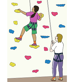 Eine Person klettert an einer Kletterwand. Eine andere Person sichert sie.