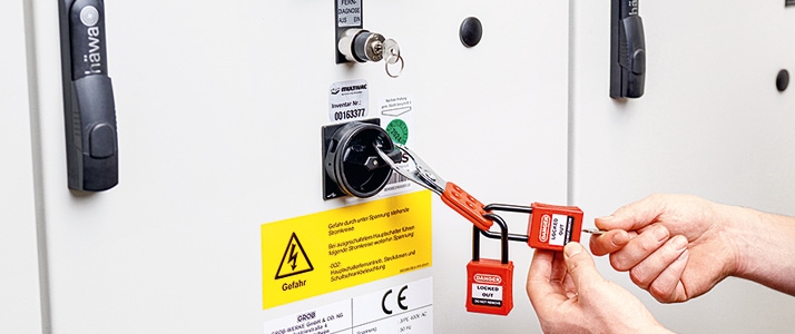 Der Hauptschalter für die Stromversorgung einer Maschine ist mit einem Vorhängeschloss verschlossen, das wiederum durch zwei weitere, namentlich gekennzeichnete Schlösser gesichert ist. Dies ist Bestandteil des Lockout-Tagout-Systems bei Multivac.
