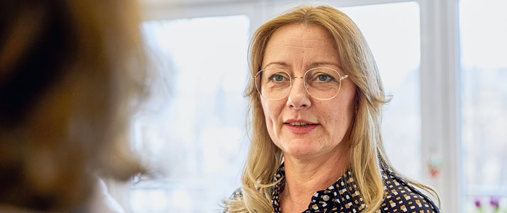 Porträt von Heimleiterin Nicole Oerder. Sie trögt eine große Brille mit dünnem Rand und langes, blondes Haar.