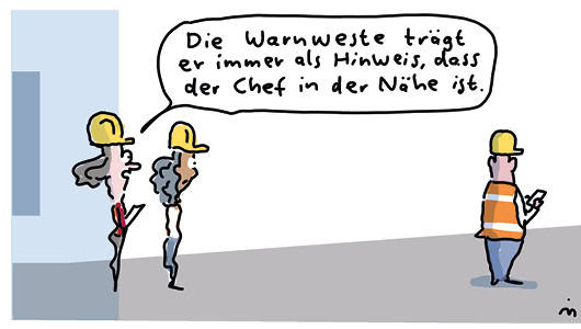 Cartoon aus dem Magazin Arbeit & Gesundheit. Zwei Frauen mit Schutzhelm stehen links im Bild und schauen auf eine Person, die rechts im Bild steht. Diese trägt Helm und Warnweste. Beide Frauen schauen diese Person an, eine der Frauen sagt in einer Sprechblase: "Die Warnweste trägt er immer als Hinweis, dass der Chef in der Nähe ist."