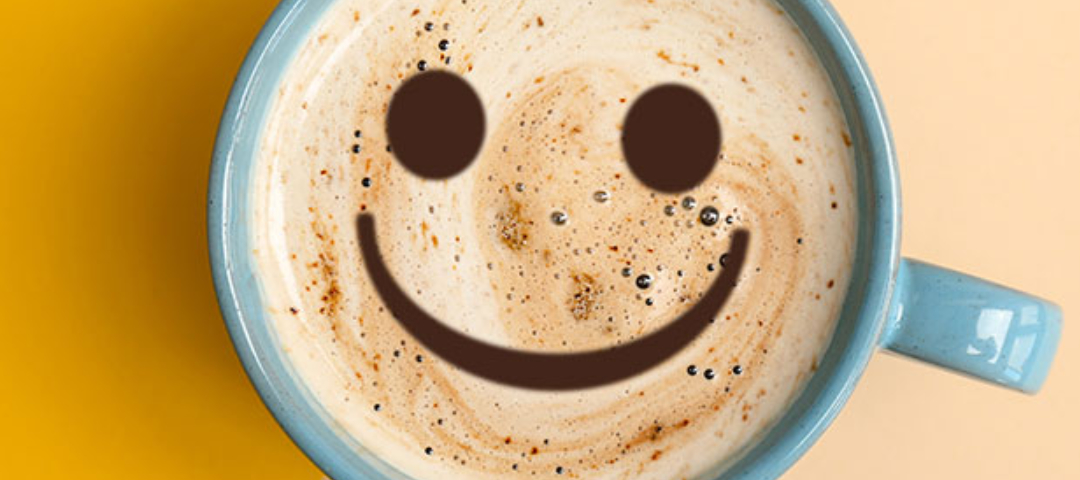 Eine Tasse Kaffee mit einem positiven Smiley.