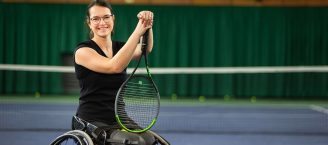 Britta Wend ist eine Rollstuhltennis-Spielerin. Das Foto zeigt sie mit dem Tennisschläger in der Tennishalle beim Training.